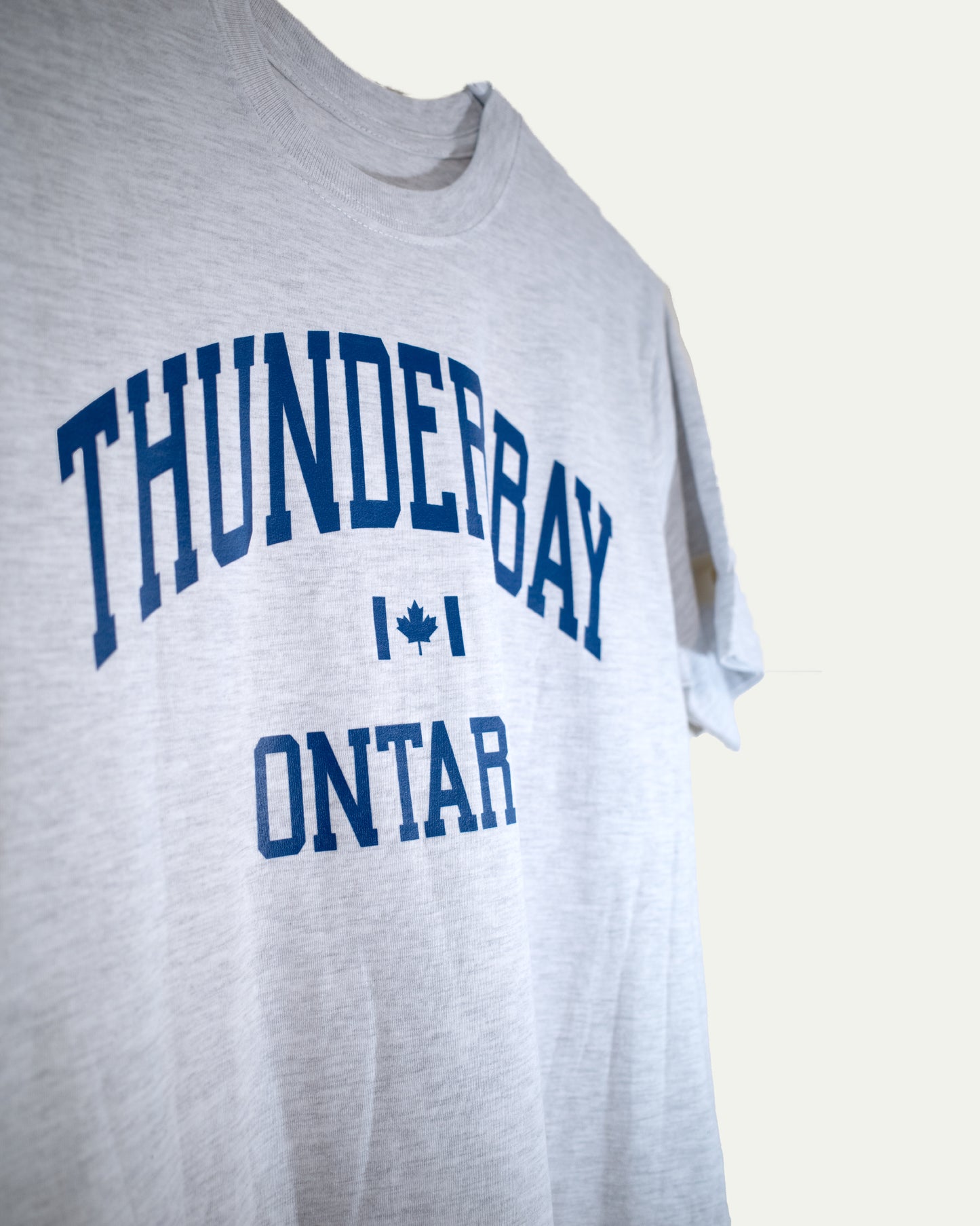 Gray t-shirt with 'Thunderbay Ontario' printed in blue on a light gray background