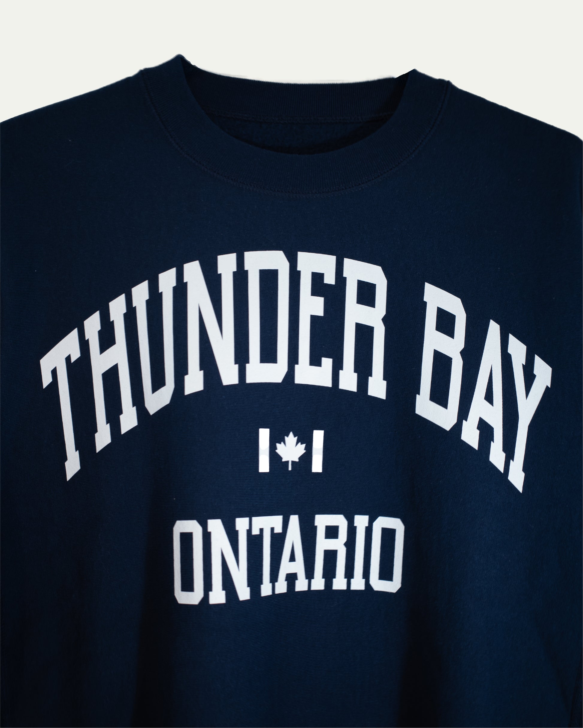 Navy blue sweatshirt with 'Thunder Bay Ontario' text and a maple leaf on a white background